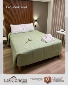 1 dormitorio con 1 cama verde y 2 toallas en LAS CONDES Hotel, en Tacna 5 fotos más