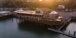 un grand bâtiment sur un quai dans l'eau dans l'établissement Anchor Lodge, à Fort Bragg 16 autres photos