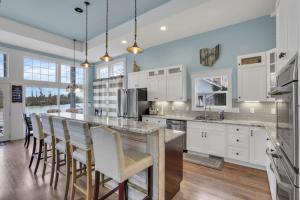 a kitchen with white cabinets and a bar with stools at The Lakehouse in Buckeye Lake