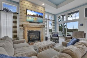 a living room with a fireplace and a tv on a wall at The Lakehouse in Buckeye Lake