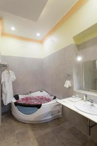 uma casa de banho com uma banheira e um lavatório em Syna Heritage Hotel em Khajuraho