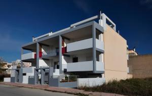 a white building with balconies on the side of a street at Elvita Spata Luxurious Villa in Spata
