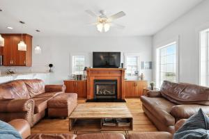 a living room with leather furniture and a fireplace at After Dune Delight in Kure Beach