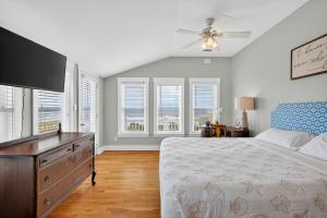 a bedroom with a bed and a ceiling fan at After Dune Delight in Kure Beach