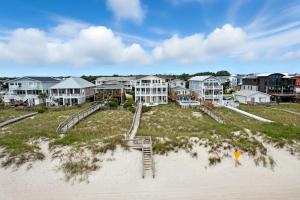 a group of houses on the beach next to the sand at After Dune Delight in Kure Beach