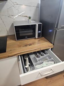 eine Mikrowelle auf einer Theke neben einem Kühlschrank in der Unterkunft Komfortowy, klimatyzowany apartament Góry Marzeń - Lesko in Lesko