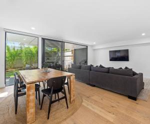 a living room with a table and a couch at Woodalla Way - Family Coastal Duplex Walk to Beach in Narrawallee