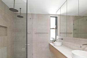 a bathroom with a sink and a glass shower at Woodalla Way - Family Coastal Duplex Walk to Beach in Narrawallee +17 photos
