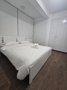 a white bedroom with a large bed with white cabinets at Maestro Family - Apartment in Larnaka