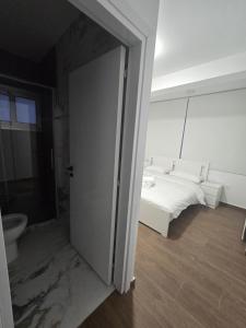 a white bedroom with a bed and a toilet at Maestro Family - Apartment in Larnaka