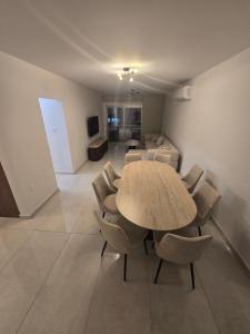 a dining room with a table and chairs in a room at Maestro Family - Apartment in Larnaka