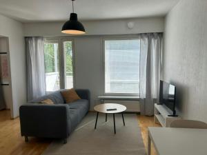 a living room with a couch and a tv at Convenient Apartment for 4 with Sauna in Törnävä