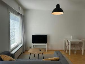 a living room with a couch and a flat screen tv at Convenient Apartment for 4 with Sauna in Törnävä +3 photos