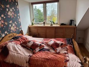 ein Bett mit Kissen darauf in einem Zimmer mit Fenster in der Unterkunft Bed en breakfast in Stad aan ʼt Haringvliet