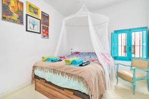 - une chambre avec un lit à baldaquin et une chaise dans l'établissement La Casita Turquesa - Zeezicht, à Almuñécar