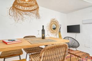 - une salle à manger avec une table et une bouteille de vin dans l'établissement La Casita Turquesa - Zeezicht, à Almuñécar