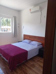 ein Schlafzimmer mit einem Bett mit einer lila Decke darauf in der Unterkunft Casa túnel 2 in Pôrto de Pedras