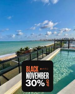 a sign for a black november sign in front of the beach at Restinga by Xtay - Studios com piscina e academia, pé na areia em João Pessoa in João Pessoa