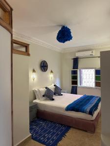 ein Schlafzimmer mit einem Bett und einer blauen Decke in der Unterkunft Riad Le Bijou de Zahra Marrakech Kasbah in Marrakesch