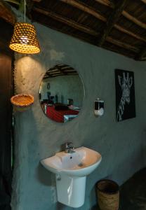 a bathroom with a sink and a mirror and a bed at Kutoka Lodge in Arusha