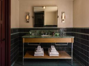 un bagno con lavandino, specchio e asciugamani di Hotel Daphne a Houston