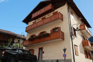 a building with wooden balconies on the side of it at Casa Brenta - Alpine Charm in Madonna di Campiglio