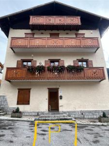 a building with a balcony with flowers on it at Casa Brenta - Alpine Charm in Madonna di Campiglio +5 photos