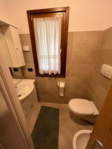 a small bathroom with a toilet and a sink at Casa Brenta - Alpine Charm in Madonna di Campiglio