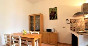 a kitchen with a wooden table and a dining room at Casetta La Meridiana in San Vito lo Capo