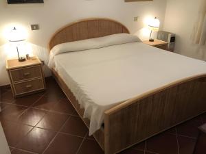 a bedroom with a large bed with two night stands at Appartamento Gelsomino vista mare in Monte Petrosu