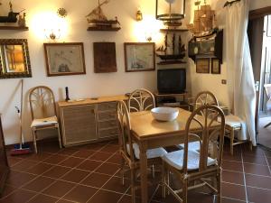 a dining room with a table and chairs and a tv at Appartamento Gelsomino vista mare in Monte Petrosu