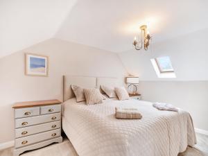 a white bedroom with a bed and a dresser at Wheelwright's Cottage in Yeaveley
