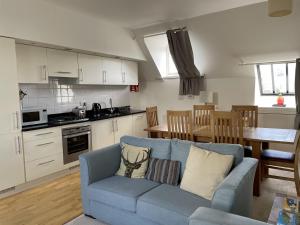 een woonkamer met een blauwe bank en een keuken bij Monastery 17 in Fort Augustus