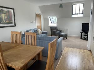 een woonkamer met een blauwe bank en een tafel bij Monastery 17 in Fort Augustus