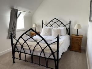 een slaapkamer met een zwart bed met witte lakens en kussens bij Monastery 17 in Fort Augustus +11 foto's