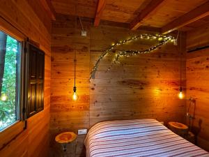 a bedroom with a bed in a wooden wall at Nature Tree House Casa sobre los árboles in Tordera +6 photos