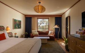 una camera d'albergo con letto, divano e finestra di Hotel Daphne a Houston