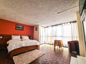 a bedroom with a bed and a large window at Hotel Las Americas in Cuenca +40 photos