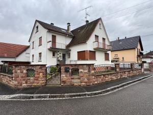 una gran casa blanca con una valla de ladrillo en Instant reposant, en Seltz