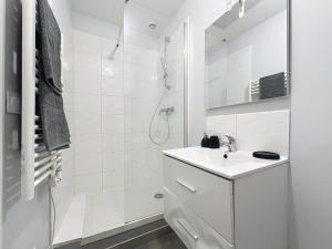 a white bathroom with a sink and a shower at Appartement confortable Oullins centre in Oullins