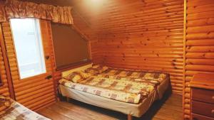 ein Schlafzimmer mit einem Bett in einem Holzzimmer in der Unterkunft Atsalama puhketalu kompleks in Atsalama + 10 Fotos