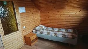 ein Schlafzimmer mit einem Bett in einem Holzzimmer in der Unterkunft Atsalama puhketalu kompleks in Atsalama