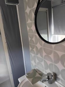 ein Badezimmer mit Waschbecken und Spiegel in der Unterkunft Le Cottage du Lavoir-La P'tite Maiz in Bourg-de-Visa