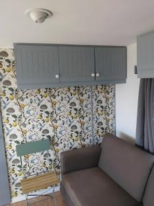 ein Wohnzimmer mit einem Sofa und einer Tapete in der Unterkunft Le Cottage du Lavoir-La P'tite Maiz in Bourg-de-Visa