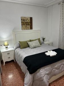 ein Schlafzimmer mit einem Bett und zwei Nachttischen in der Unterkunft Apartamento espacioso El Olivo in Córdoba