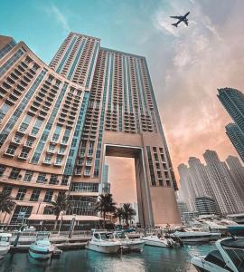 a large building with boats in the water and a plane at Emaar Dubai Marina Residences - formerly Address Dubai Marina in Dubai