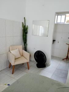 a living room with a chair and a mirror at Hospedagem da Lu in Paraty
