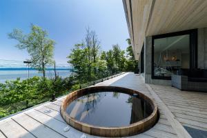a bath tub on the deck of a house at Le Föss, Fleuve, Sauna & Spa in Petite-Rivière-Saint-François