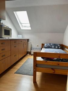 ein Schlafzimmer mit Bett und eine Küche mit Dachfenster in der Unterkunft Wohnung für Monteure & Handwerker in Neustadt am Kulm