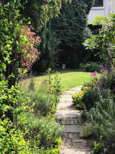 un jardin avec un chemin de pierre et des fleurs dans l'établissement Hideaway cottage, à Kirkhamgate